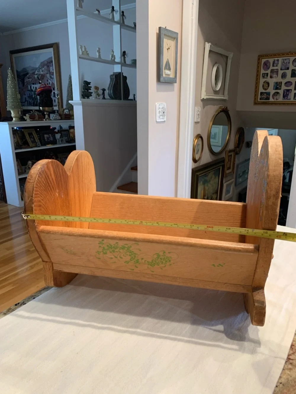 Vintage wooden doll cradle heart-shaped design painted with floral details.